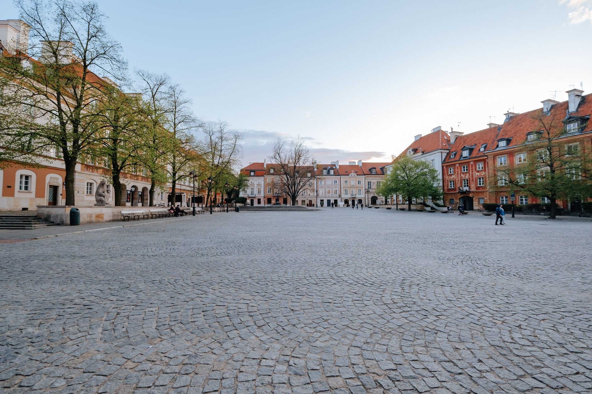 A picturesque empty European square with cobblestone pavement and colourful buildings at daytime.